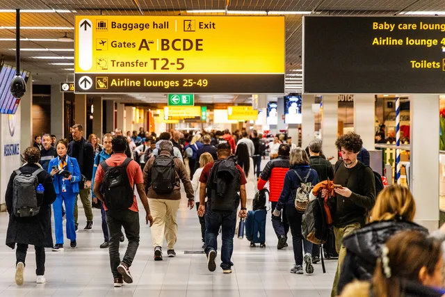 Drukte op Schiphol. Mensen gaan vaker op vakantie.