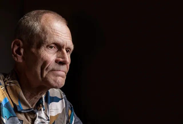 Henk Westerveld voor een zwarte achtergrond.