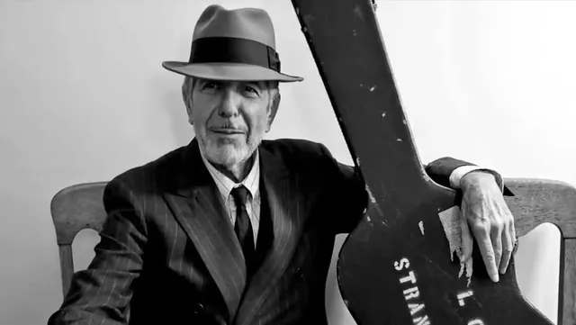 Leonard Cohen met gitaarkoffer.