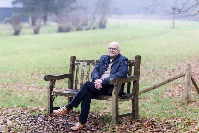Joop Gankema op een houten bankje in de natuur.