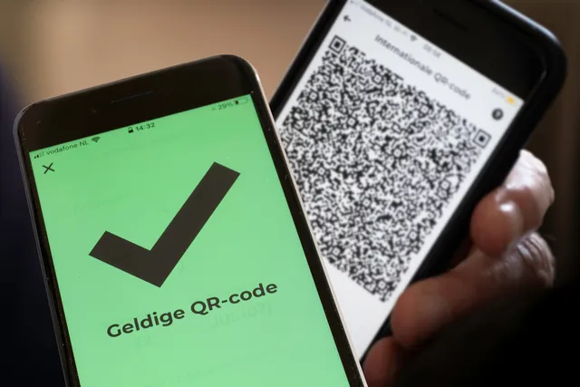 AMSTERDAM, NETHERLANDS - SEPTEMBER 20 2021: Dutch text "Valid QR code" on the green screen of a smartphone meaning the owner of the other phone has been vaccinated or tested negative.